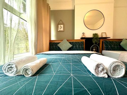 a bedroom with a large bed with towels on it at Delux Rooms Near City Centre in London
