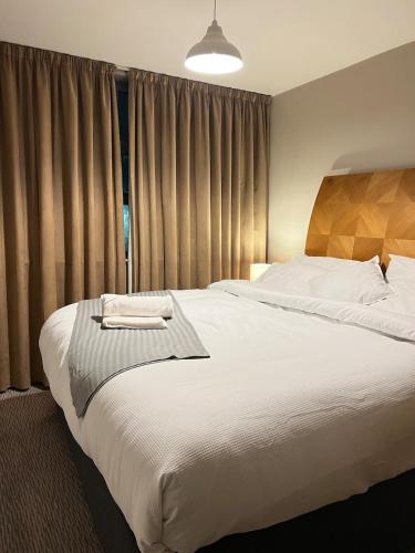a bedroom with a large white bed with curtains at Comfy 2bed flat next to Motorpoint Arena in Nottingham