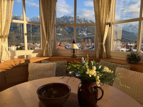 a dining room with a table with a vase of flowers at Apartment Sonnenhang in Wallgau