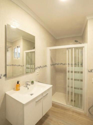 a white bathroom with a sink and a shower at Apartamento moderno en el centro de Tavernes in Tavernes de Valldigna