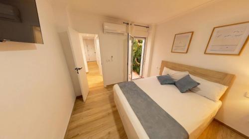 a bedroom with a large white bed with blue pillows at Apartamento moderno en el centro de Tavernes in Tavernes de Valldigna