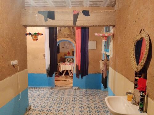a bathroom with a sink and a room with a table at Gîte Palma Eagle Ziz Canyon in Er Rachidia