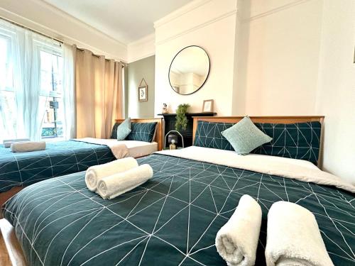 a bedroom with two beds and a mirror at Delux Rooms Near City Centre in London