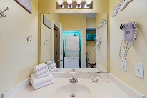 a bathroom with a sink and a mirror at SB50 Saltwater Sanctuary in Sunset Beach
