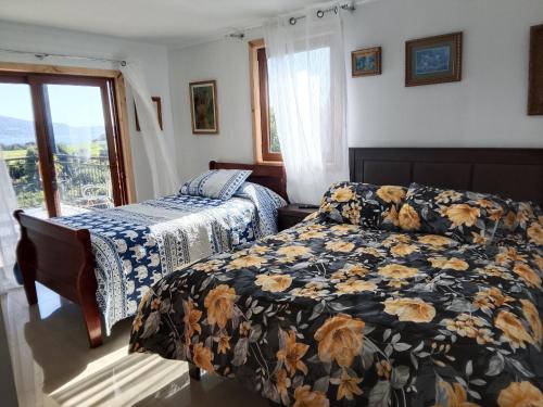 a bedroom with two beds and a window at Regreso al Encanto in Puyehue