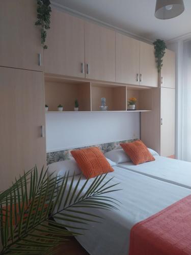 a bedroom with two beds with orange pillows at Apartamento El Horrín ( Colunga ) in Colunga