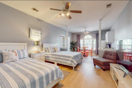 a bedroom with two beds and a ceiling fan at SB72 Sea Trail Golf-Beach Condo in Sunset Beach