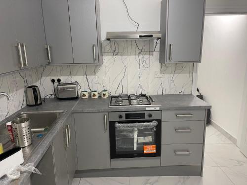a small kitchen with a stove and a sink at Princess shahzadi in Manchester