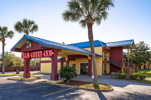 a front view of a main grocery store with a palm tree at OYO Hotel Pensacola I-10 & Hwy 29 in Pensacola