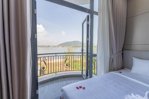 a bedroom with a bed and a balcony with a view at Loc Binh Hotel in Thôn Phú An