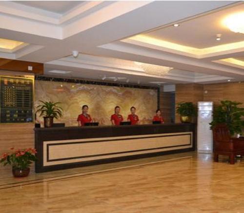 un grupo de hombres parados detrás de un mostrador en un vestíbulo en Guangzhou JinTang Hotel, en Guangzhou