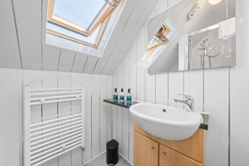 a white bathroom with a sink and a skylight at Cloudhowe Cottage Ensuite Rooms & Studio Inverness in Inverness