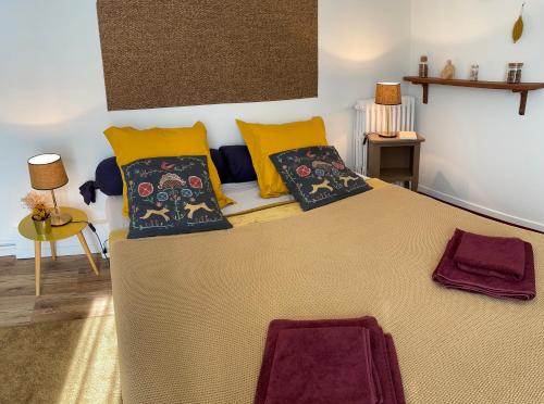 a bedroom with a large bed with yellow pillows at Suite - Chambre Cherry Plum in Coulommiers
