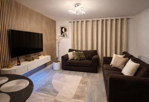 a living room with a couch and a flat screen tv at Ebbsfleet Luxe in Swanscombe