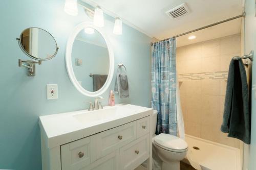 a bathroom with a sink and a toilet and a mirror at Bayfront Bliss Your Waterfront Getaway in Ocean City