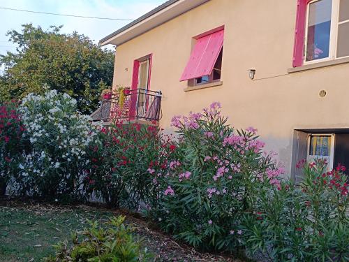a house with a bunch of flowers in front of it at Chambres d'hôtes Chez nous in Nantheuil