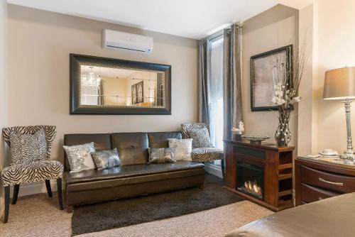 a living room with a leather couch and a mirror at Dreams2Reality | Historic Branson Hotel - Haven Suite - Downtown in Branson