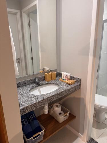 a bathroom with a sink and a mirror at Apartamento novo aconchegante na Ondina in Salvador