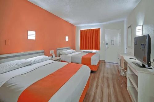 a hotel room with two beds and a flat screen tv at Value Extended Stay in Maple Shade