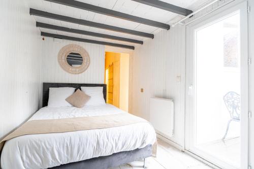 a bedroom with a large bed and a window at Prestige Étretat in Étretat