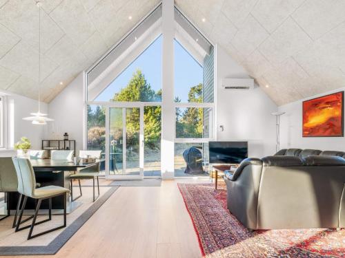 a living room with a dining table and a fireplace at 5 star holiday home in Rømø in Toftum