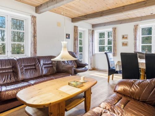 a living room with leather furniture and a wooden table at 5 star holiday home in Gram in Gram