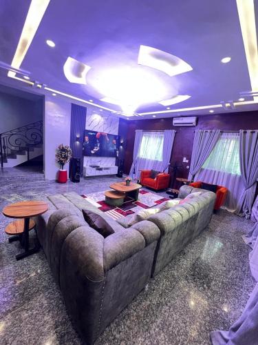 a living room with a large couch in a room at Shortlet247 in Hausa