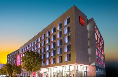 a building with a red sign on top of it at Leonardo Hotel Dortmund in Dortmund