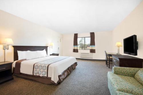 a hotel room with a bed and a couch at Americas Best Value Inn Hobbs in Hobbs