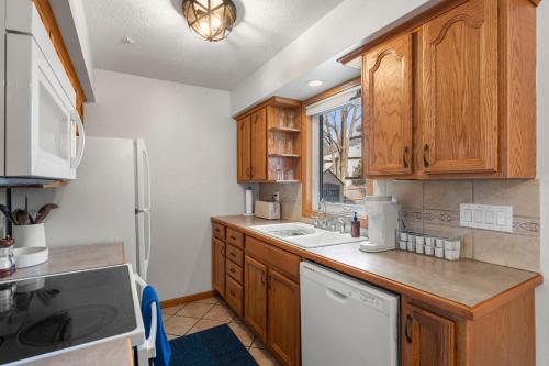 a kitchen with wooden cabinets and a white refrigerator at The Nicollet Nook Unit 2 in Minneapolis