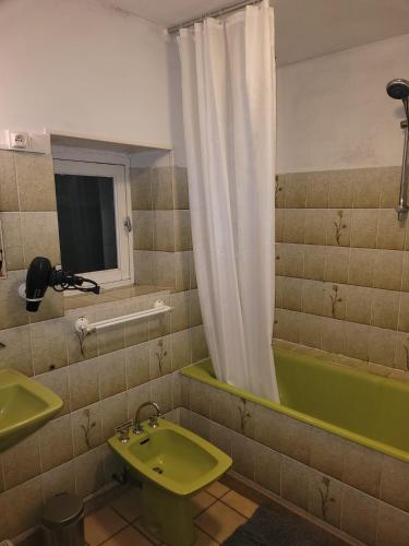 a bathroom with a green sink and a tub at La Balnière Normande in Hambye