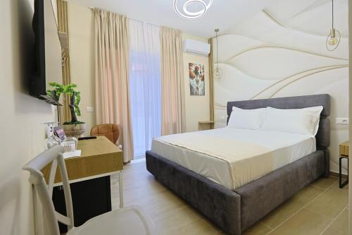 a bedroom with a bed and a desk and a television at Jera Rooms in Durrës