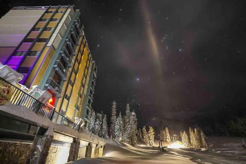 a building at night with christmas trees in the snow at Ski in out King bed Suite Mountain View in Kirkwood
