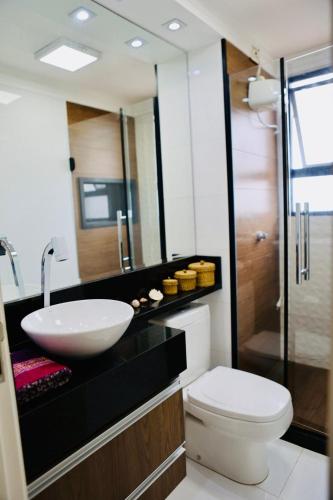 a bathroom with a sink and a toilet and a mirror at Detalhes que te convida a aproveitar in Sorocaba