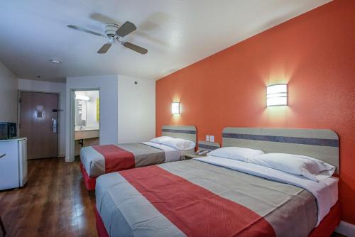 two beds in a hotel room with orange walls at Motel 6-Nephi, UT in Nephi