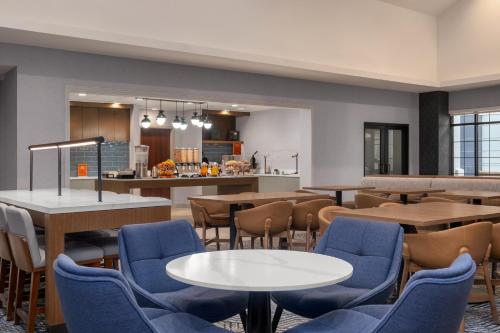 a restaurant with tables and chairs and a kitchen at Homewood Suites by Hilton Fresno in Fresno
