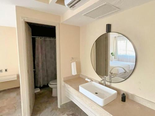 a white bathroom with a sink and a mirror at Quinta Nina Playa del Carmen - Solo Adultos in Playa del Carmen