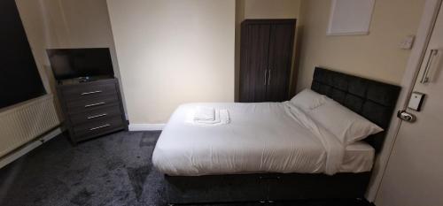 a small bedroom with a bed and a television at SELF CHECK-IN QUICK ROOMz WAKEFIELD in Wakefield