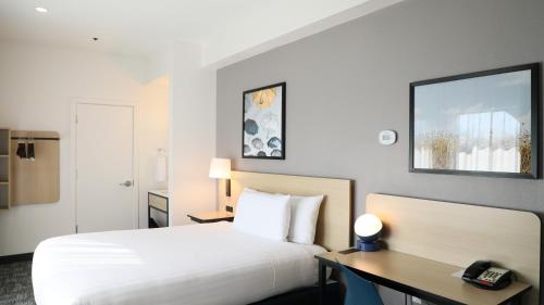 a hotel room with a white bed and a desk at Hotel Vue in Mountain View