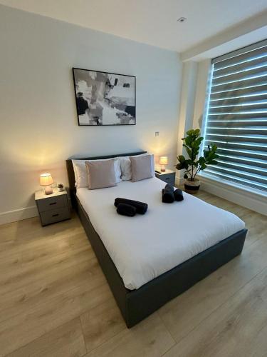 a bedroom with a large bed with two black bags on it at 37 Syward Place in Chertsey