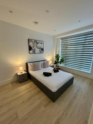 a bedroom with a bed with two lamps and a window at 37 Syward Place in Chertsey