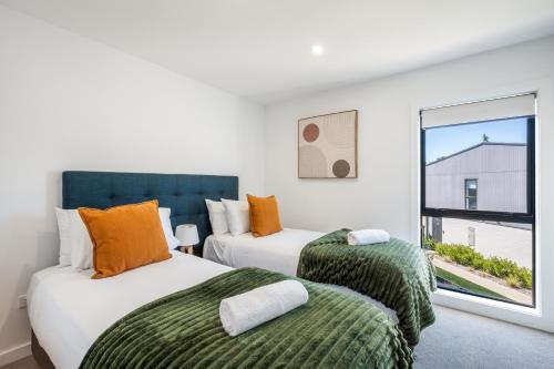 two beds in a room with a window at Flexible Bed Options, Private Back Yard, Car Park in Albert Town