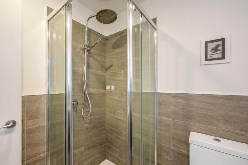 a shower with a glass door in a bathroom at Flexible Bed Options, Private Back Yard, Car Park in Albert Town