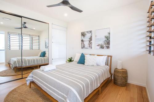 a bedroom with a bed and a mirror at Breeze at Salt - Beachside, Heated Pool, Wheelchair Access in Kingscliff