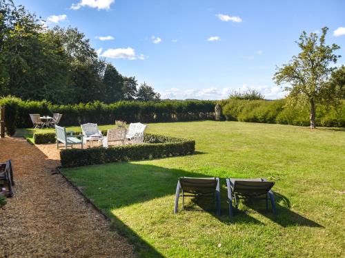 a group of chairs sitting on the grass in a yard at Green Farm Cottage in Redgrave