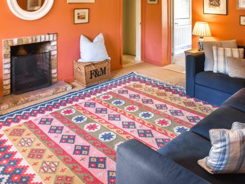 a living room with a couch and a fireplace at Green Farm Cottage in Redgrave