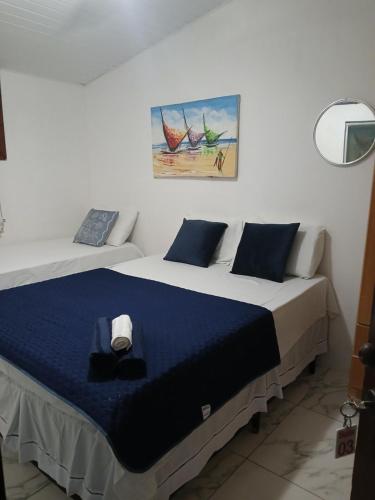 a bedroom with a bed with a blue blanket at ElRancho Suites in Itaparica