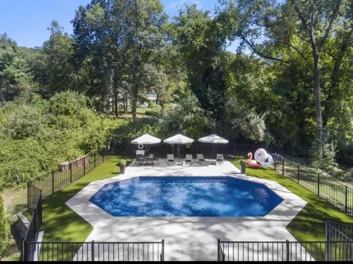 a person is sitting next to a swimming pool at Renovated Retreat with Heated Pool in Redding