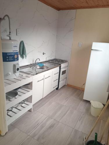 a kitchen with a sink and a refrigerator at Vientos de Olavarria -Alquiler temporal in Olavarría