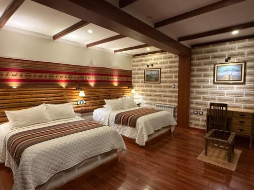 two beds in a room with brick walls at Hotel de Sal Atipax in Uyuni